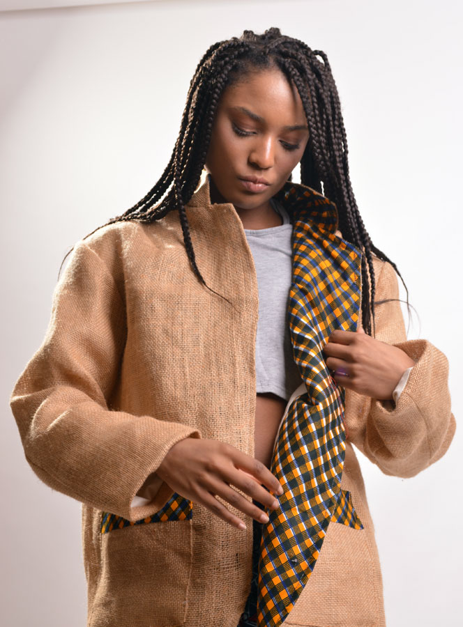 woman inspecting burlap jacket with ankara leapel and trims