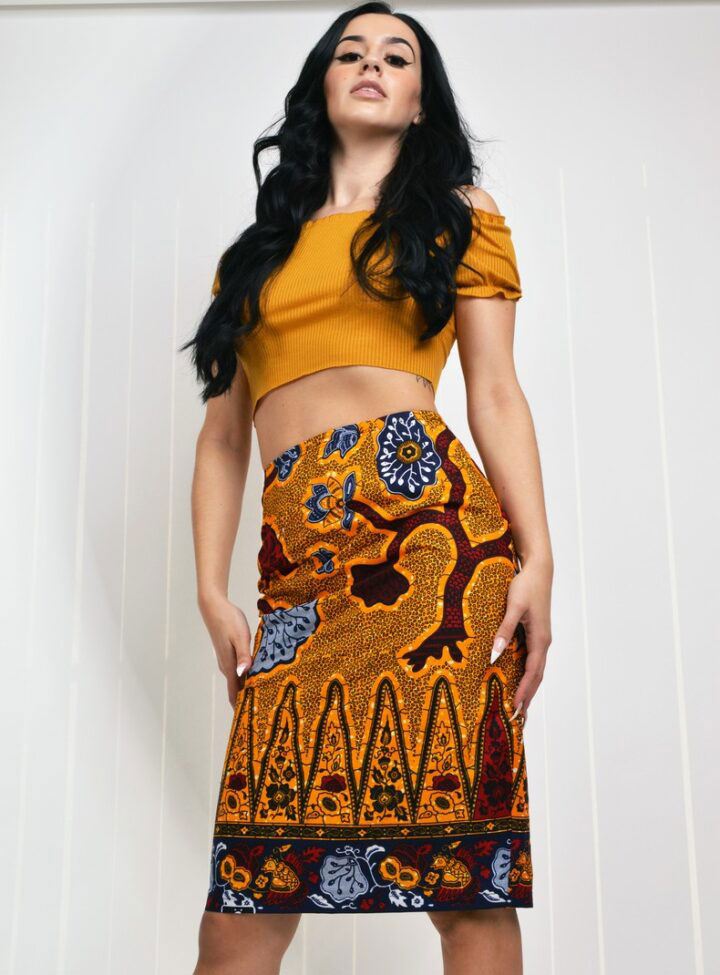 model wearing gold and black ankara midi pencil skirt