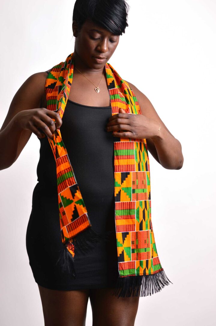 woman adjusting african kente scarf