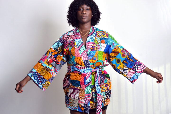 model showing off the wide legs of a belted patchwork kimono with v neck