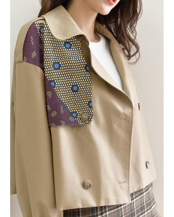 close up of a trench coat with african print patch on the side front